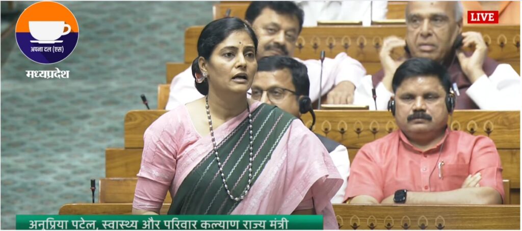 live image of Anupriya Patel, Minister of State for Health and Family Welfare, speaking in Rajya Sabha with other MPs in the background.